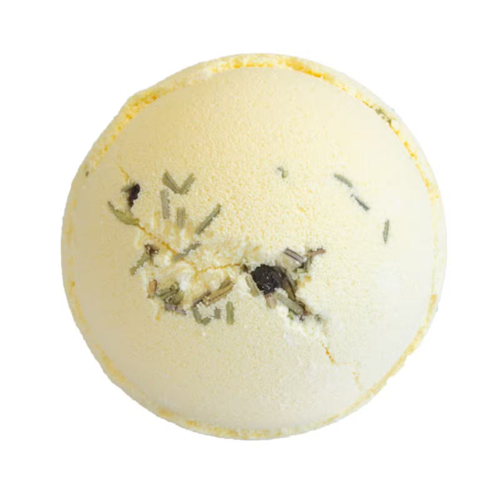 Cream gin and tonic with lime bath bomb with dried rosemary flecks on white background
