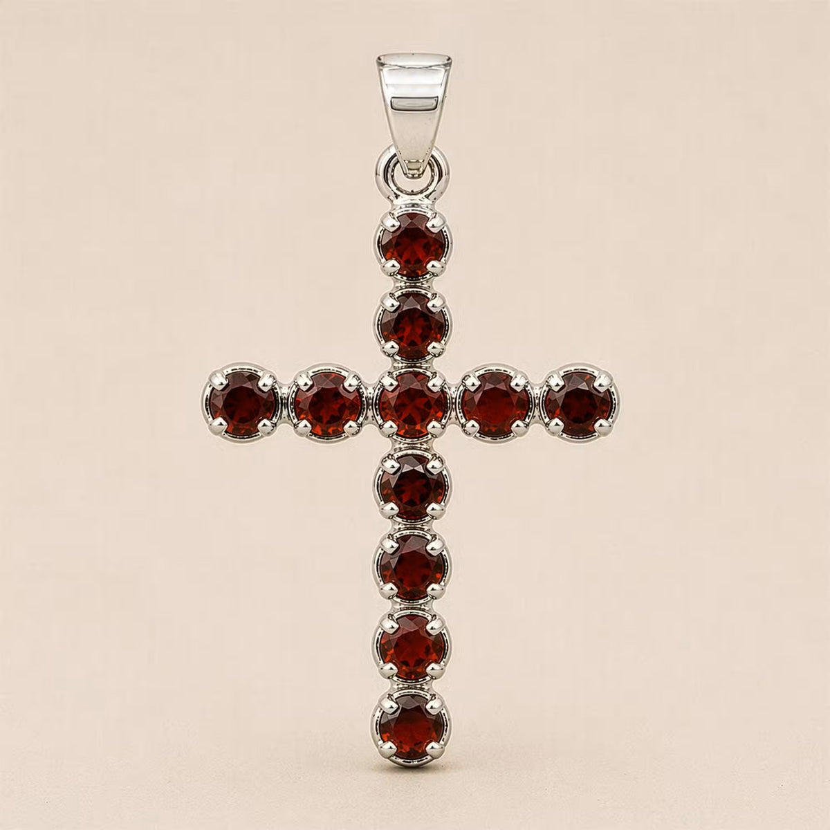 Silver plated garnet cross pendant close up, deep red gemstone