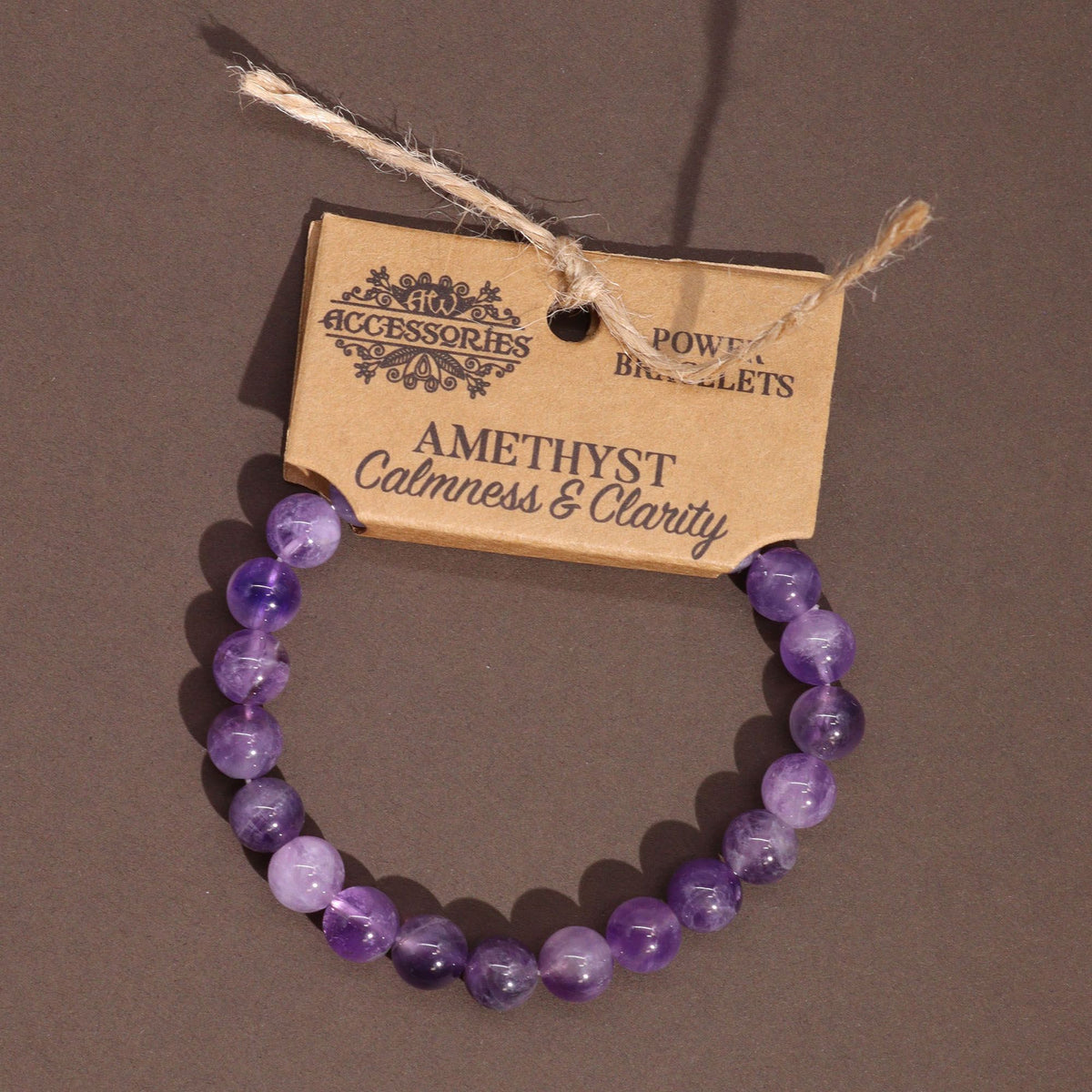 Amethyst bead bracelet hanging against a brown background