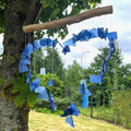 Handcrafted blue glass heart wind chime — recycled blue glass pieces forming a heart shape hanging from driftwood bar on white background