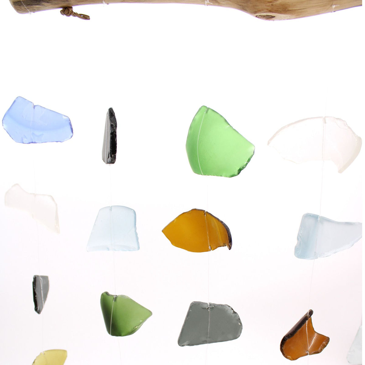 Multi colour glass wind chime close-up — blue, green, amber and grey sea glass on driftwood