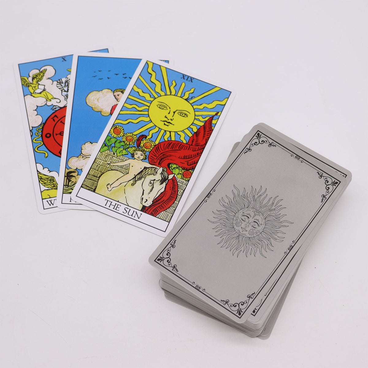 Traditional Arcana tarot cards fanned out showing The Sun card with card backs classic tarot deck