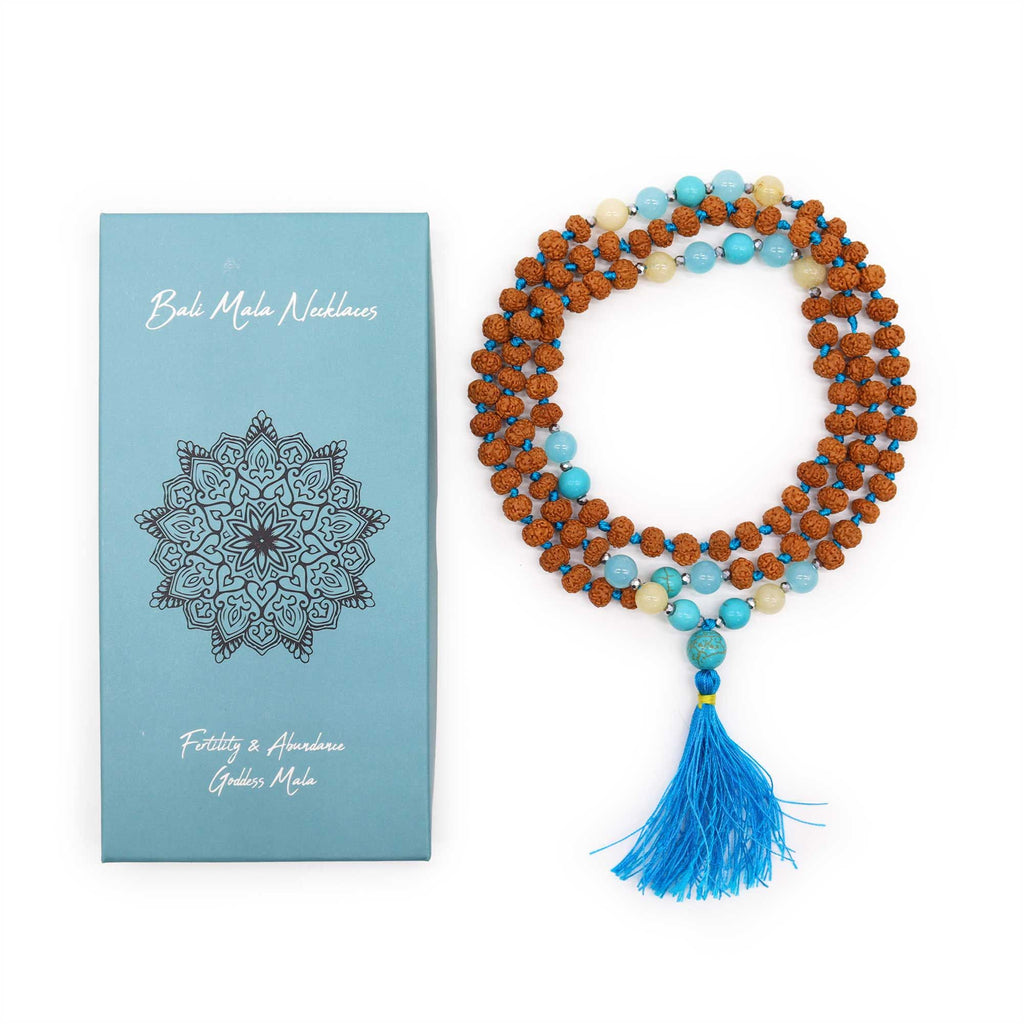 Colourful Rudraksha bead mala necklace with a blue tassel, displayed beside its blue gift box