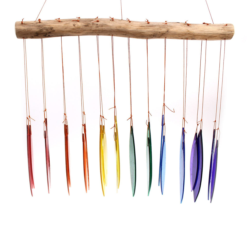 Rainbow glass wind chime — side view on white background showing elongated leaf-shaped glass pieces in rainbow spectrum from red to violet on driftwood bar